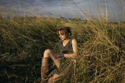 Woman is sitting in the field