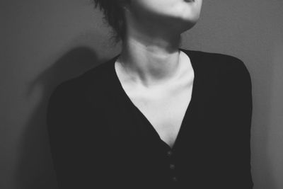 Midsection of young woman against gray background
