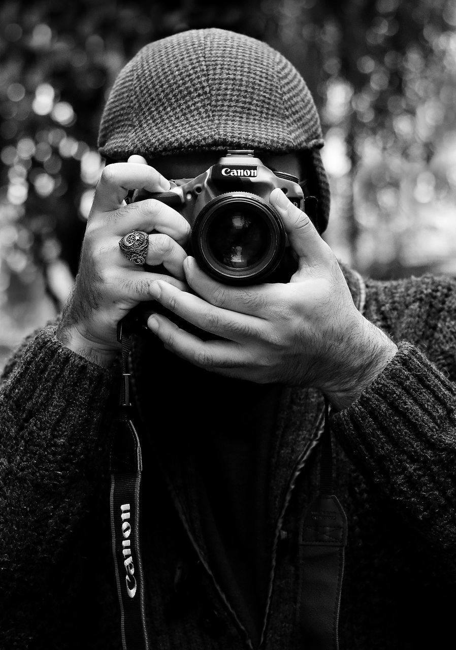 camera - photographic equipment, photography themes, photographing, one person, activity, technology, photographic equipment, holding, camera, clothing, digital camera, real people, photographer, leisure activity, front view, portrait, lifestyles, winter, occupation, warm clothing, digital single-lens reflex camera, slr camera, obscured face, scarf