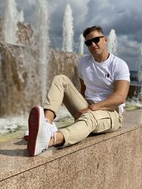 Full length of young man sitting outdoors