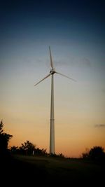 Wind turbines on field at sunset