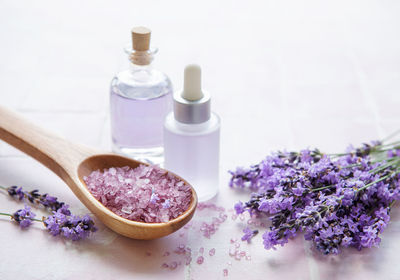 Spa products and lavender flowers on a pink tile background. aromatherapy lavender bath salt 