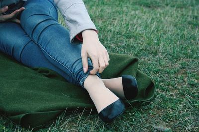 Low section of man relaxing on grassy field