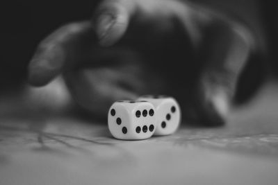 Close-up of hand holding dices on table