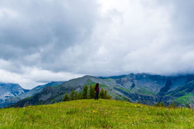 A young female hiker on a break during a hike on a cloudy summer day in the french alps
