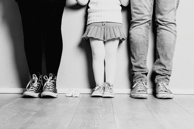 Low section of people walking on hardwood floor