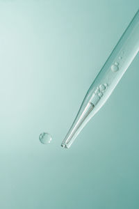 Pipette with cosmetic product in water with bubbles.