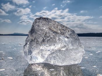 Close-up of ice crystals on rock against sky