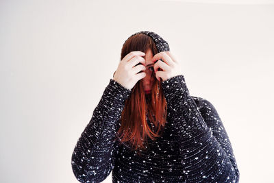 Close-up of woman wearing hat against white background