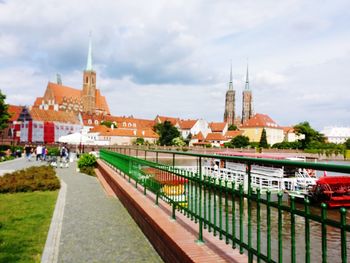 Canal amidst buildings in city against sky