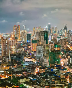 High angle view of illuminated buildings in city against sky at night