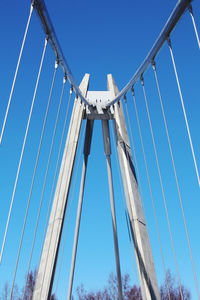 Low angle view of suspension bridge against clear blue sky