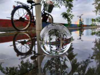 Close-up of bicycle wheel by lake