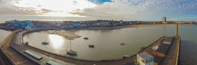 Panoramic view of river and buildings against sky during sunset