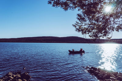 People on boat against clear sky