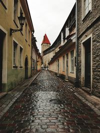 Surface level of footpath amidst buildings against sky