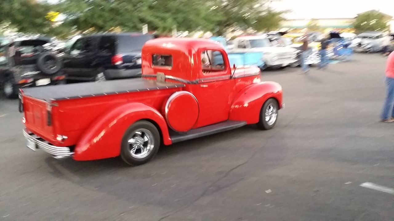 transportation, land vehicle, mode of transport, car, red, street, road, on the move, travel, stationary, focus on foreground, outdoors, selective focus, vehicle, day, blurred motion, motion, parking, parked, traffic