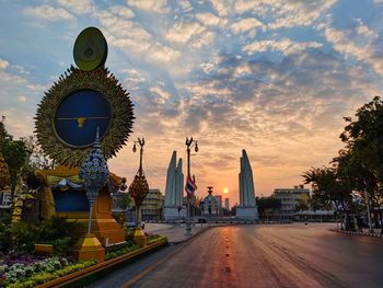 Clock tower amidst buildings against sky during sunset