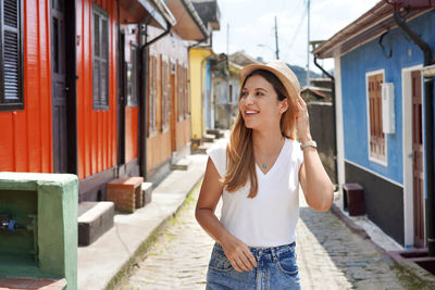 Portrait of stylish happy tourist woman visiting paranapiacaba village, sao paulo, brazil