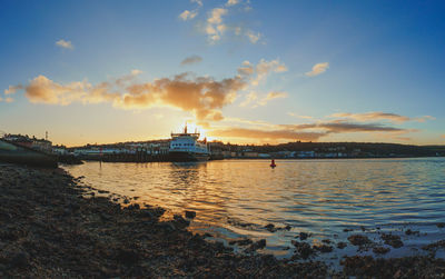 Wide angle view of a ferry ship docked in a seaside town during a gorgeous sunset