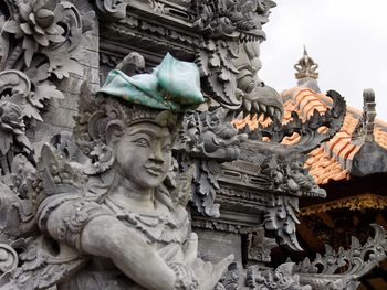 Low angle view of statue against temple