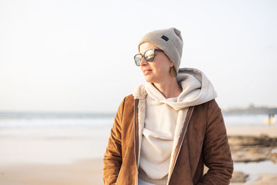 Portrait of young woman wearing hat standing at beach