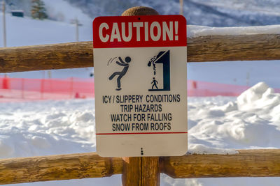 Information sign on wooden post during winter