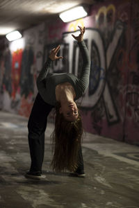 Full length of woman doing stunt in tunnel