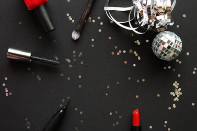 Directly above shot of various make-up objects on black table