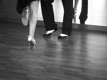 Low section of woman and man standing on hardwood floor