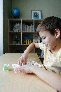 Child playing diy dot game for fingers. useful game for development of childs fingers