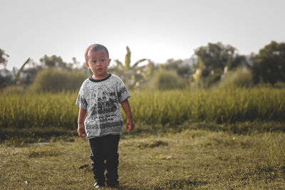 Portrait of young man standing on field