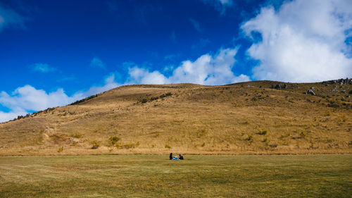 Scenic view of land and mountains against sky