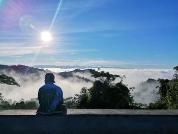 Rear view of man looking at waterfall