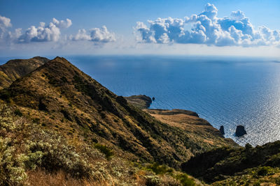 Scenic view of sea and mountains against sky