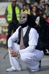 Full length of man sitting on street