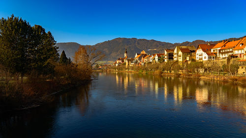 Scenic view of lake by buildings against sky