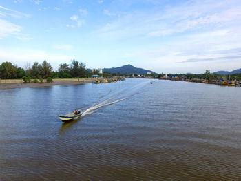 Boats sailing in lake against sky