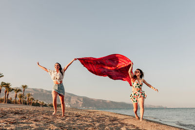 Woman standing on beach against clear sky