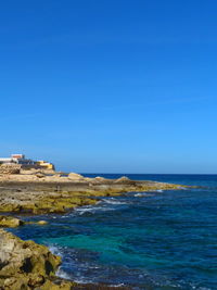 Scenic view of sea against clear blue sky