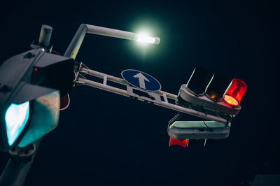 Low angle view of illuminated lighting equipment against sky at night