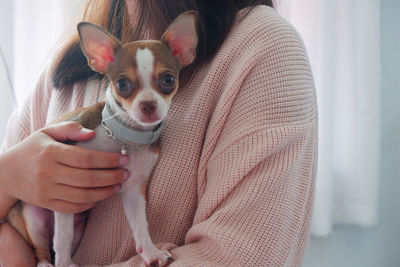 Midsection of woman holding small