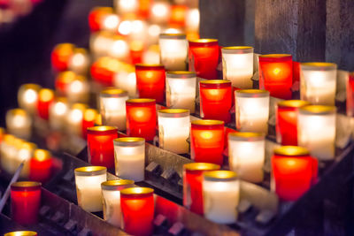 Close-up of lit candles in row