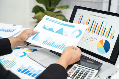 Midsection of businessman using laptop at office