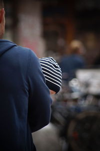 Rear view of man holding umbrella