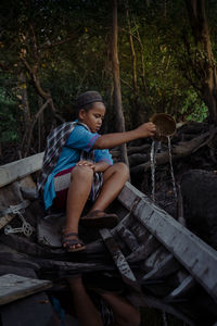 Portrait of young woman sitting in forest