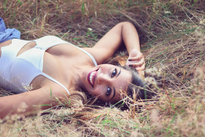 Portrait of young woman lying on grass