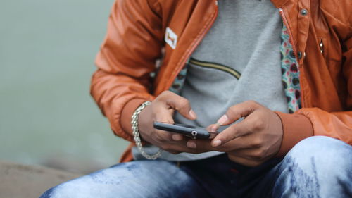 Midsection of man using mobile phone