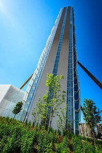 Low angle view of skyscraper against blue sky