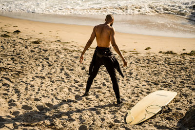 Full length of shirtless man standing on beach